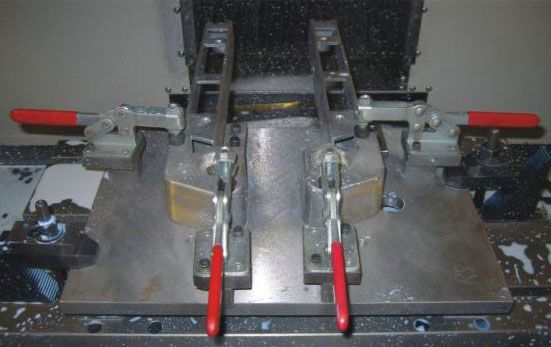 High-precision industrial machining setup with clamps and a metal workpiece for manufacturing or assembly processes.