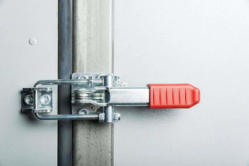 Secure industrial door latch with safety handle on metal door, used for high security and safety in commercial or warehouse facilities.