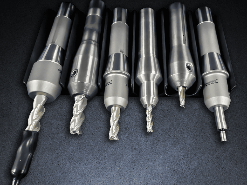 Drill bits and machining tools displayed on a black surface for industrial manufacturing and precision engineering.
