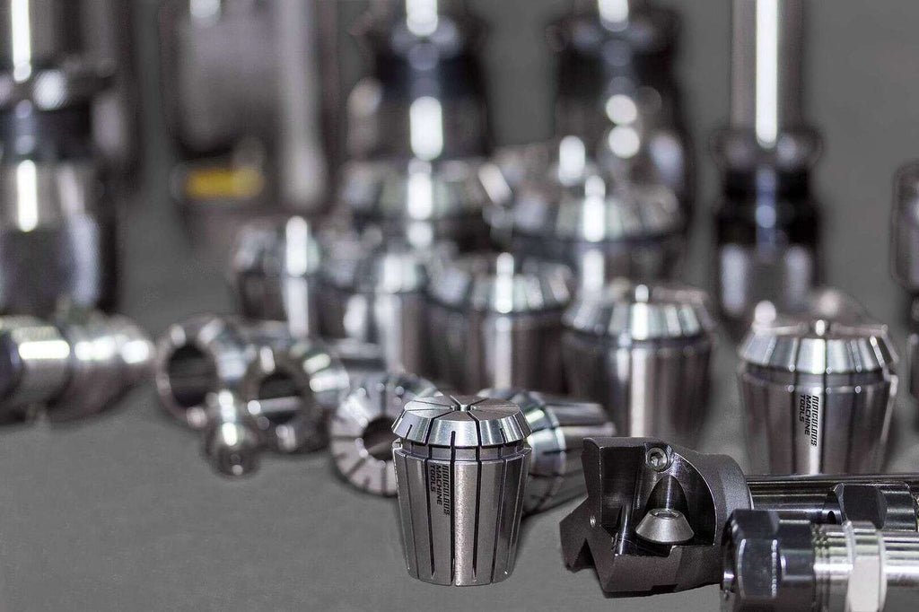 Precision CNC machine tool holders and collets displayed on a workbench, emphasizing high-quality industrial manufacturing equipment.