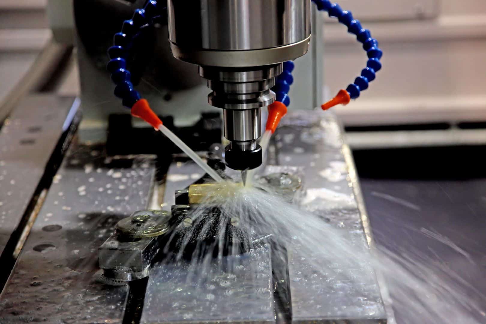 High-precision CNC machining process with coolant fluid cooling metal component on industrial machine.