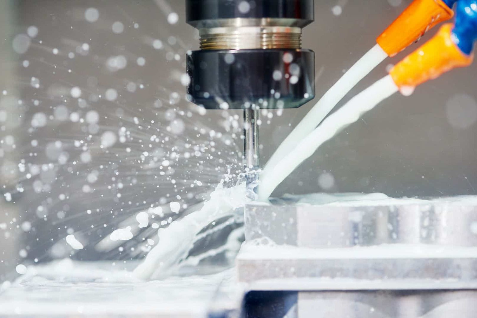 High-precision CNC machining process with coolant spray, showcasing advanced manufacturing technology and metalworking precision.