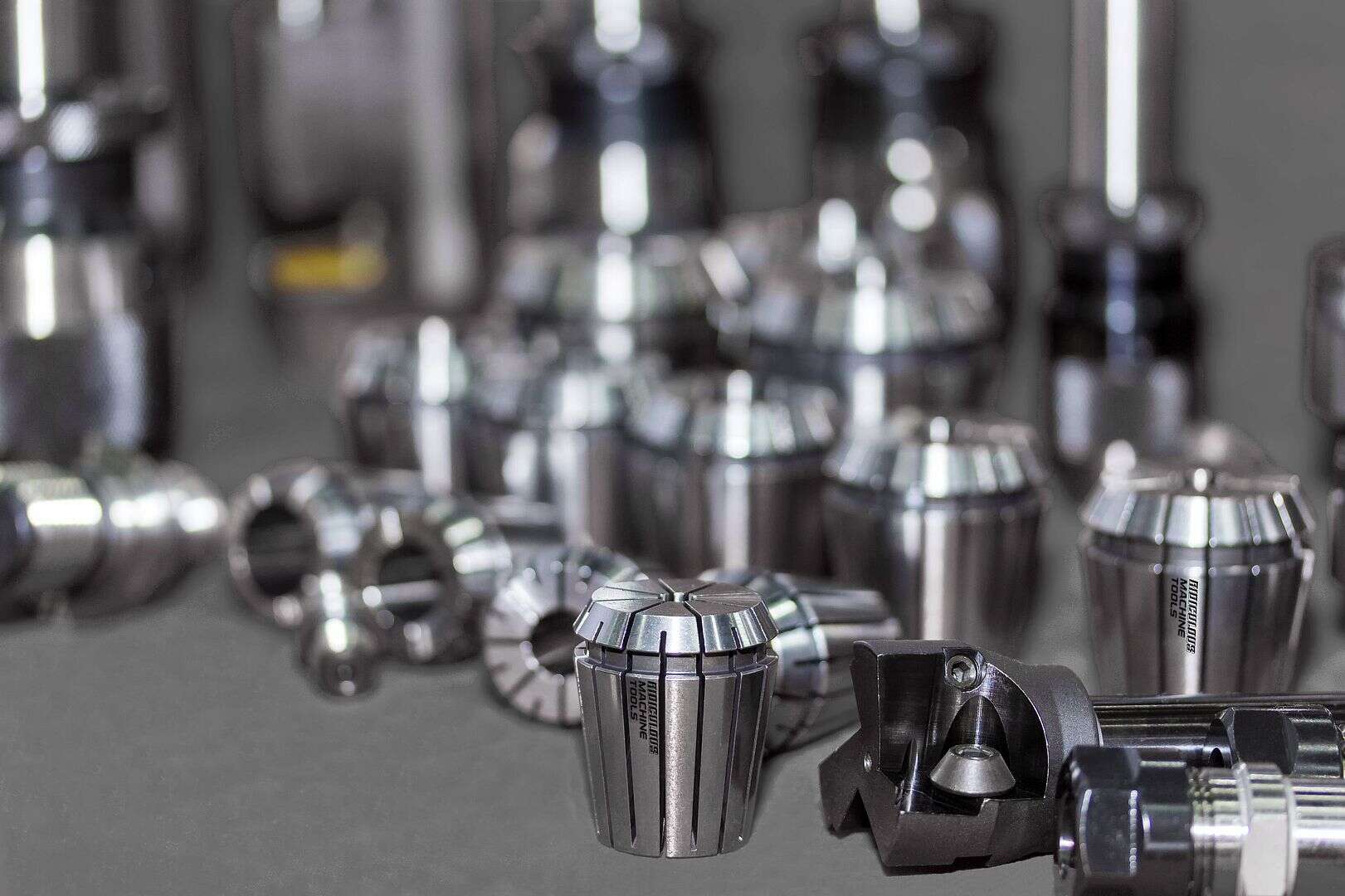 Precision CNC machine tool holders and collets displayed on a workbench, emphasizing high-quality industrial manufacturing equipment.