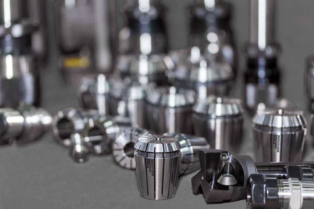 Precision CNC machine tool holders and collets displayed on a workbench, emphasizing high-quality industrial manufacturing equipment.