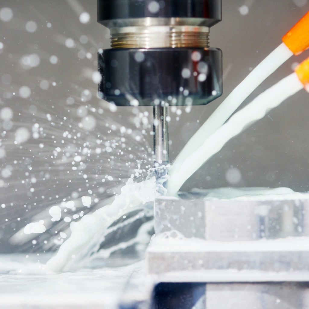 High-precision CNC machining process with coolant fluid cooling metal component on industrial machine.